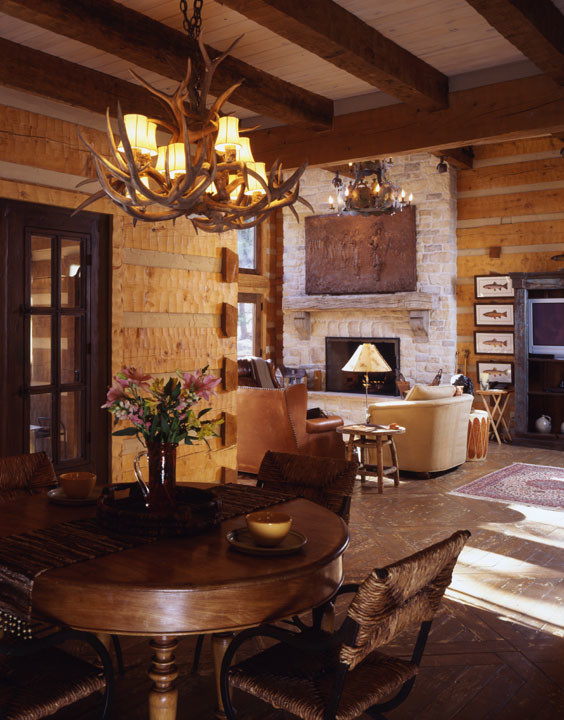 Exemple d'un grand salon montagne ouvert avec parquet foncé, une cheminée standard et un manteau de cheminée en pierre.