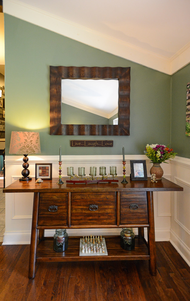 Réalisation d'un grand salon tradition ouvert avec un mur vert, un sol en bois brun, une cheminée standard, un manteau de cheminée en bois, un téléviseur indépendant et un sol marron.