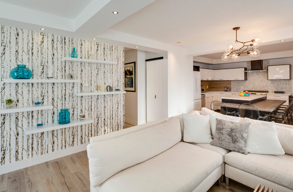 Kleines, Offenes Modernes Wohnzimmer mit weißer Wandfarbe, Laminat, Hängekamin, gefliester Kaminumrandung, verstecktem TV und braunem Boden in Vancouver