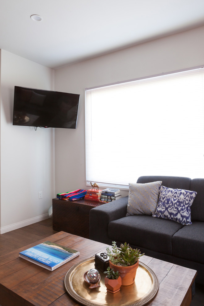 Ispirazione per un piccolo soggiorno moderno aperto con pareti bianche, pavimento in legno massello medio e TV a parete