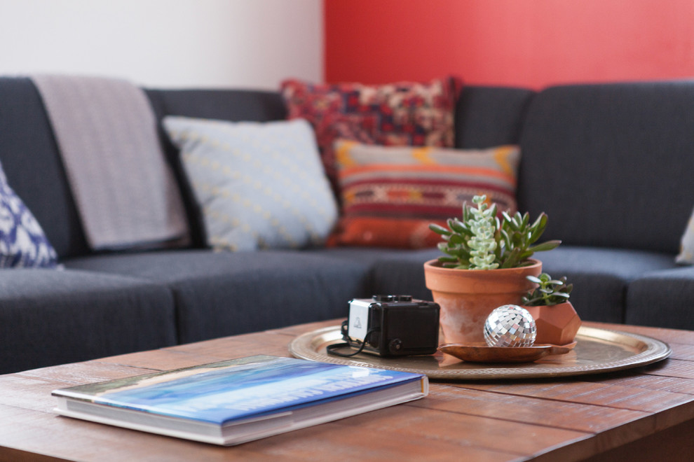 Immagine di un piccolo soggiorno minimalista aperto con pareti rosse, pavimento in legno massello medio e TV a parete