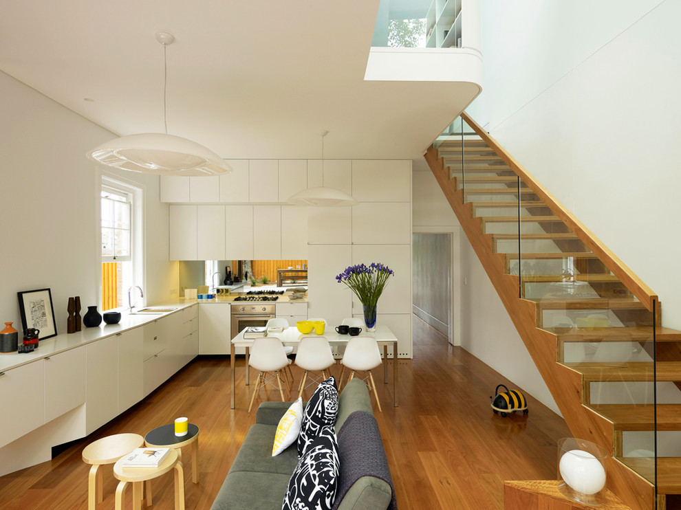 Offenes Modernes Wohnzimmer ohne Kamin mit weißer Wandfarbe und braunem Holzboden in Sydney