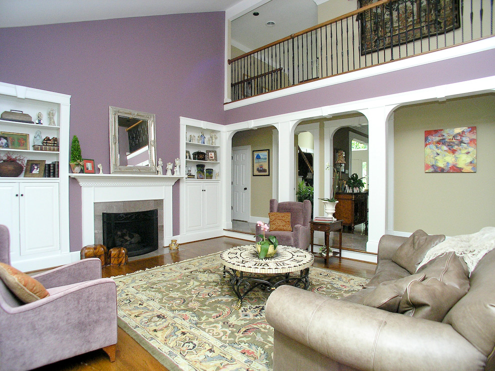 На фото: большая парадная, двухуровневая гостиная комната в классическом стиле с фиолетовыми стенами, паркетным полом среднего тона, стандартным камином и фасадом камина из камня без телевизора