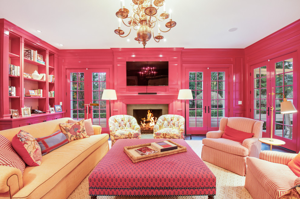 Пример оригинального дизайна: изолированная гостиная комната в классическом стиле с розовыми стенами, темным паркетным полом, стандартным камином и телевизором на стене