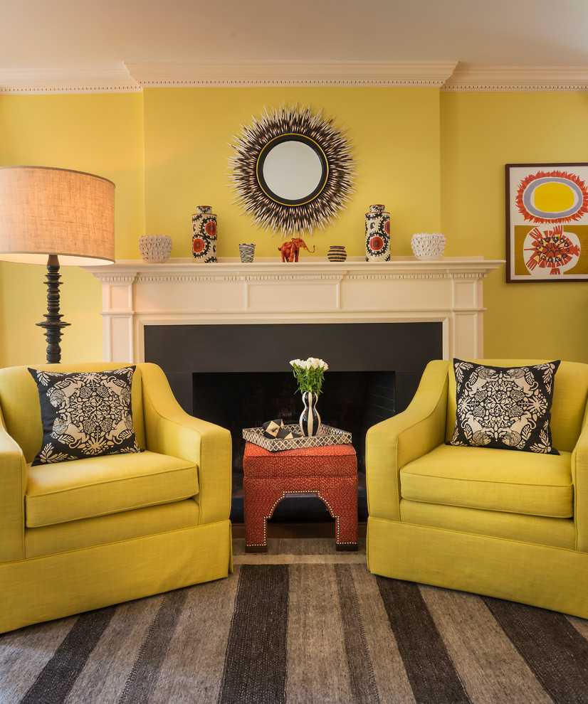 Réalisation d'un salon tradition avec une salle de réception, un mur jaune, un sol en bois brun, une cheminée standard et un manteau de cheminée en pierre.