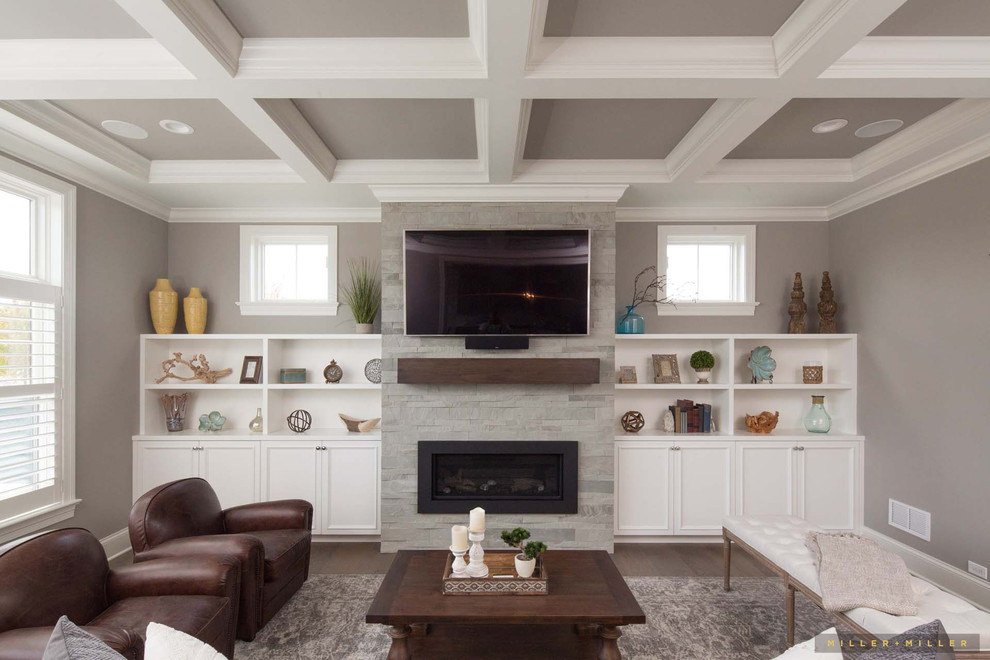 Inspiration for a medium sized country open plan living room in Chicago with a reading nook, grey walls, medium hardwood flooring, a standard fireplace, a stone fireplace surround, a wall mounted tv and brown floors.