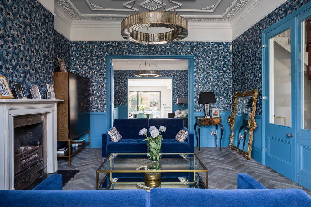 Mittelgroßes, Abgetrenntes Stilmix Wohnzimmer mit blauer Wandfarbe, dunklem Holzboden, Kamin, Kaminumrandung aus Metall, TV-Wand und braunem Boden in London