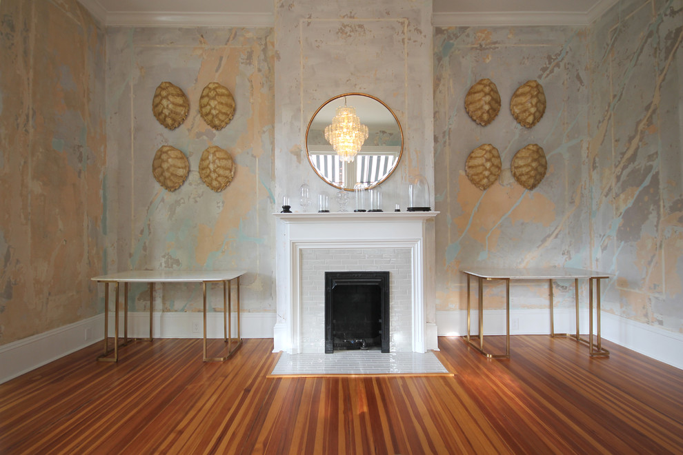 Klassisk inredning av ett mycket stort separat vardagsrum, med ett finrum, orange väggar, mellanmörkt trägolv, en standard öppen spis, en spiselkrans i gips och brunt golv