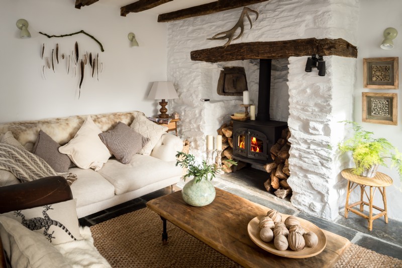 Exemple d'un salon nature avec un sol en ardoise, un poêle à bois et un manteau de cheminée en pierre.