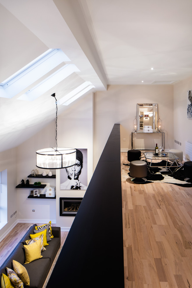 Immagine di un grande soggiorno design stile loft con pareti beige, parquet chiaro e TV autoportante