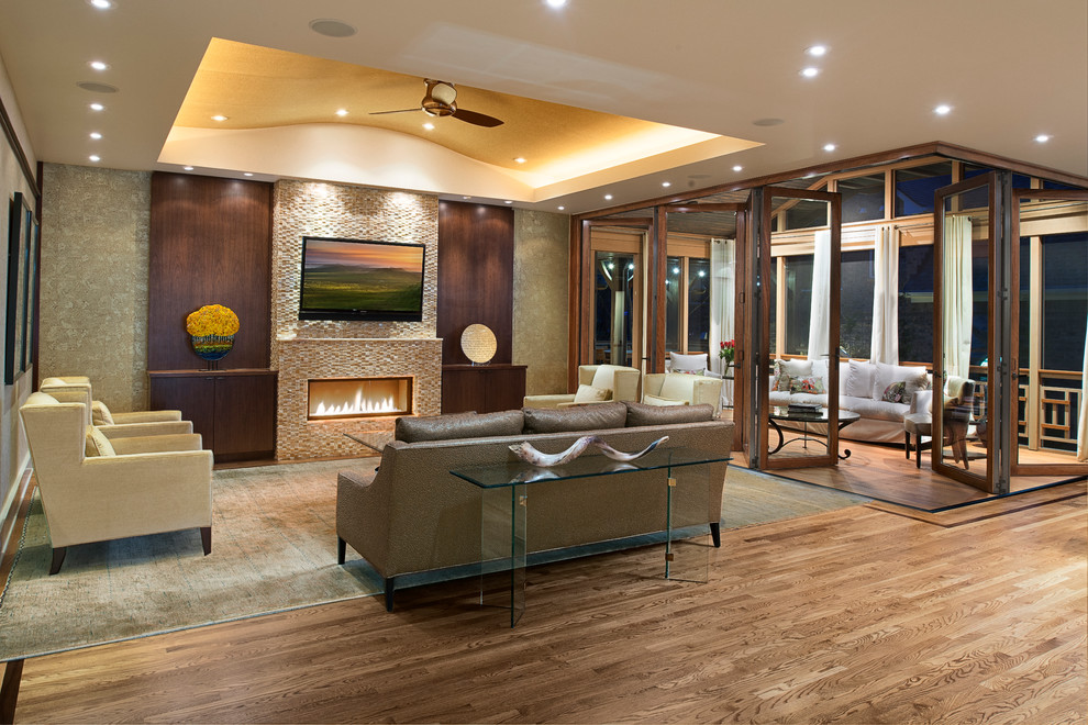 Стильный дизайн: гостиная комната в современном стиле с фасадом камина из плитки, коричневым диваном и ковром на полу - последний тренд