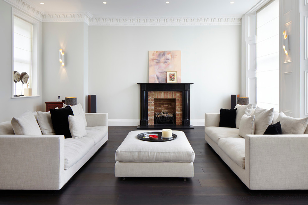 Photo of a contemporary living room in London with white walls, a standard fireplace and a brick fireplace surround.