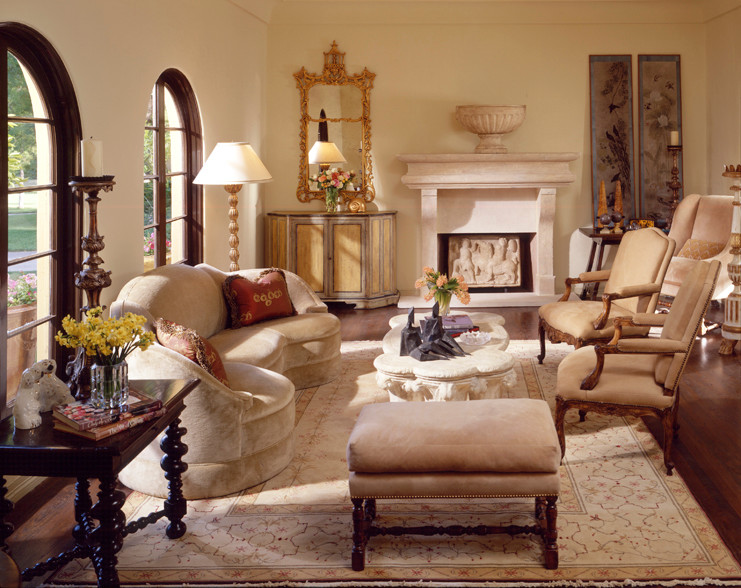 Cette photo montre un grand salon méditerranéen avec un mur beige, parquet foncé, une cheminée standard et un manteau de cheminée en pierre.