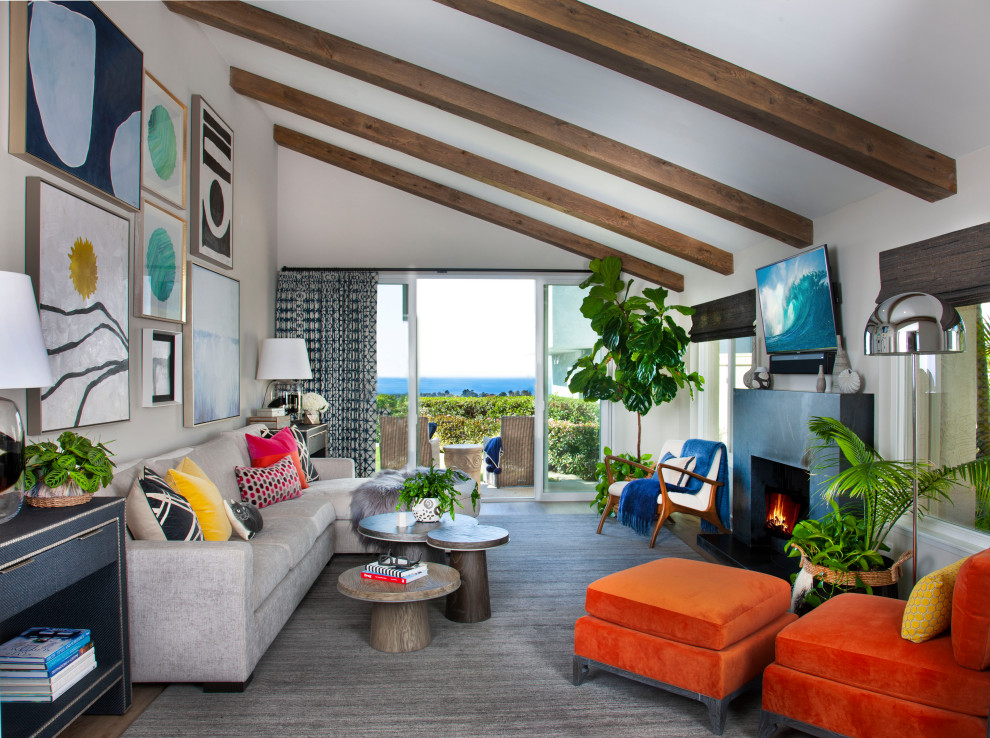 Offenes Klassisches Wohnzimmer mit weißer Wandfarbe, dunklem Holzboden, Kamin, TV-Wand, braunem Boden, freigelegten Dachbalken und gewölbter Decke in San Diego