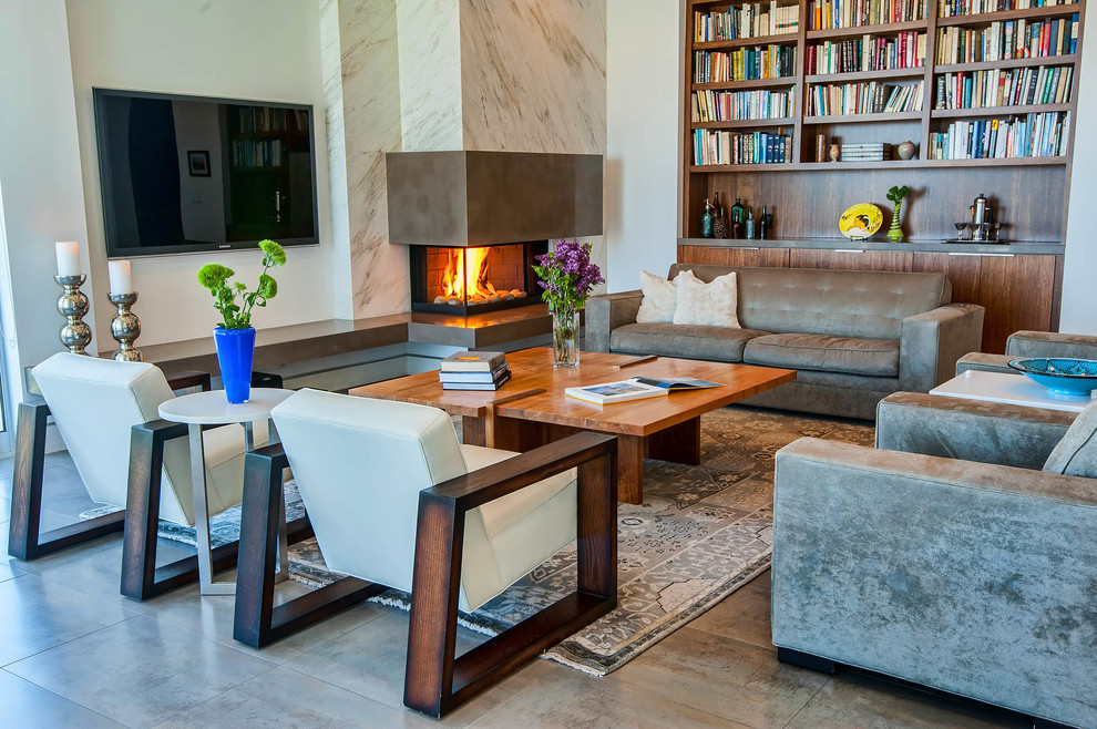 ロサンゼルスにあるコンテンポラリースタイルのおしゃれなリビング (コーナー設置型暖炉、グレーの床、茶色いソファ) の写真