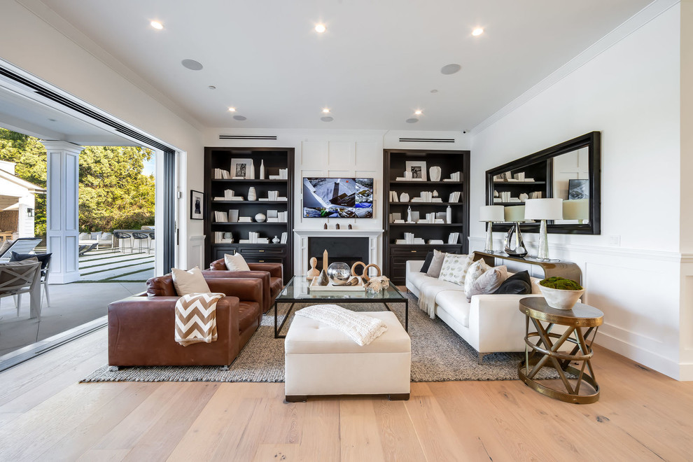 Inspiration for a transitional medium tone wood floor and brown floor living room remodel in Los Angeles with white walls, a standard fireplace and a wall-mounted tv