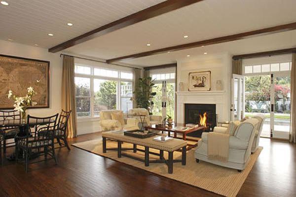 Living room - large traditional formal and enclosed medium tone wood floor living room idea in Los Angeles with white walls, a standard fireplace, a wood fireplace surround and a concealed tv