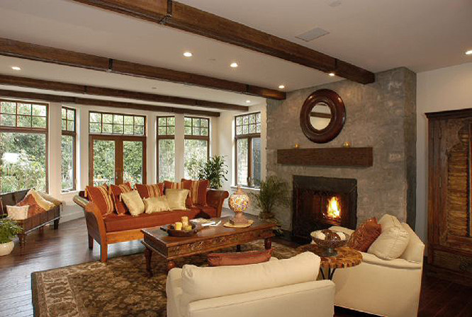 Foto de salón para visitas cerrado, mediterráneo, grande, con paredes blancas, suelo de madera oscura, todas las chimeneas, marco de chimenea de piedra y televisor retractable