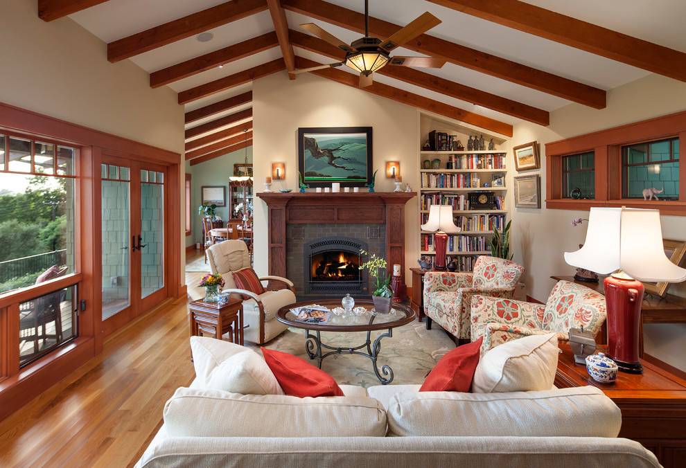 Aménagement d'un salon classique ouvert avec une bibliothèque ou un coin lecture, un mur beige, une cheminée standard et un manteau de cheminée en brique.