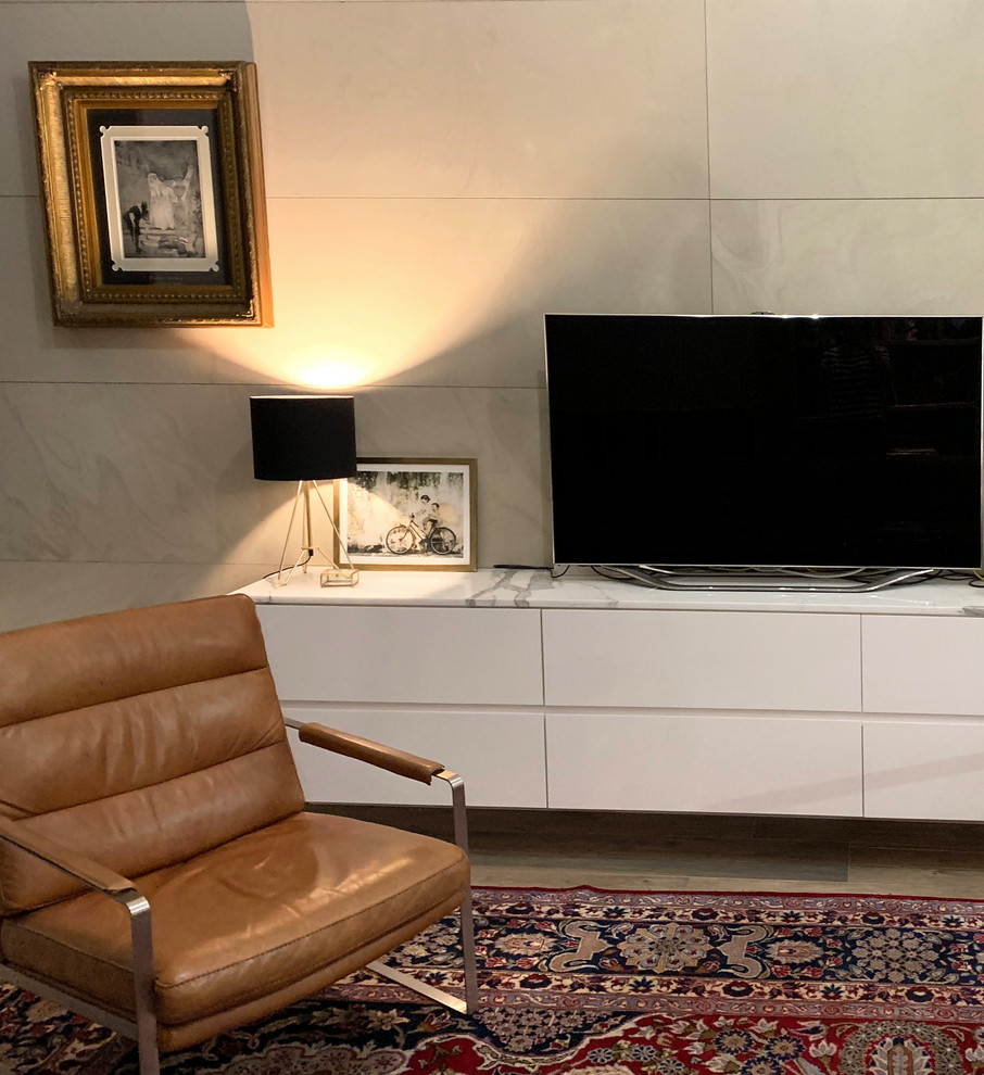 シドニーにある高級な広いコンテンポラリースタイルのおしゃれなLDK (ライブラリー、ベージュの壁、セラミックタイルの床、石材の暖炉まわり、据え置き型テレビ、ベージュの床) の写真