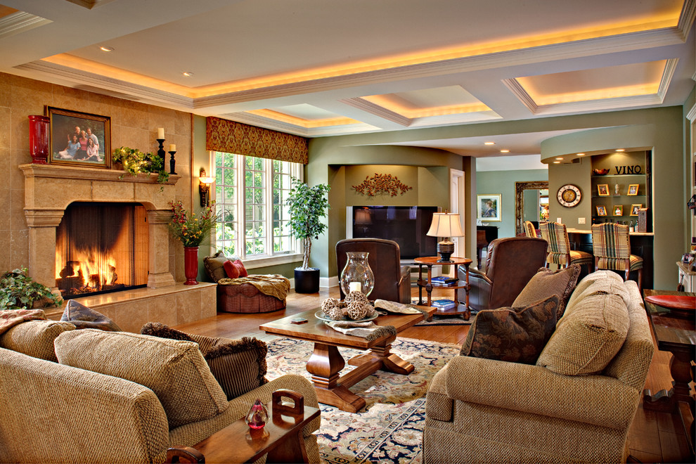 Großes, Offenes Klassisches Wohnzimmer mit grüner Wandfarbe, braunem Holzboden, Kamin und Kaminumrandung aus Stein in Chicago