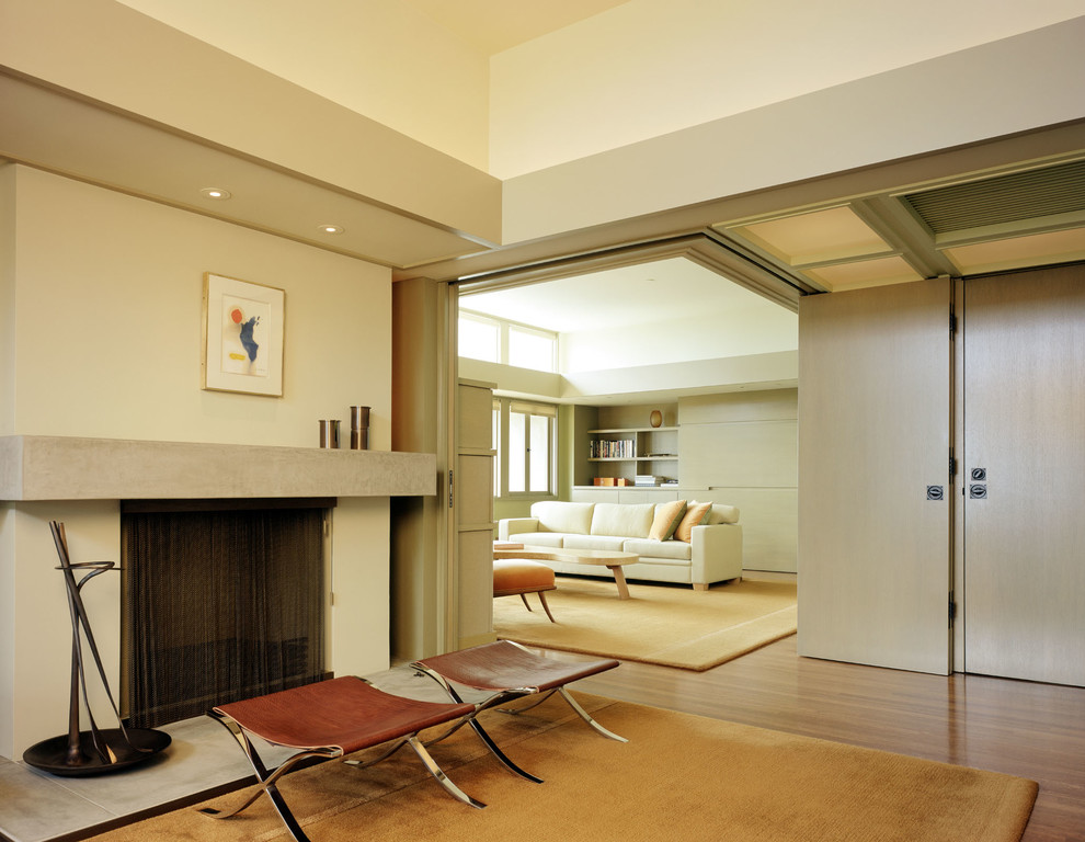 Esempio di un soggiorno minimalista con pareti beige e camino classico
