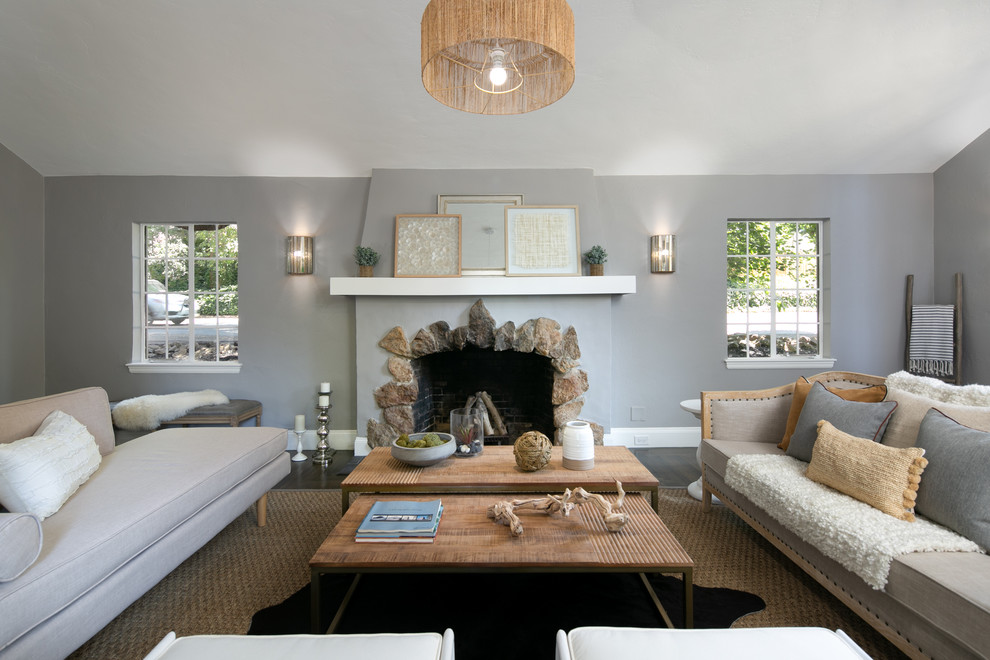 На фото: гостиная комната в стиле неоклассика (современная классика) с серыми стенами, темным паркетным полом, стандартным камином и коричневым полом без телевизора