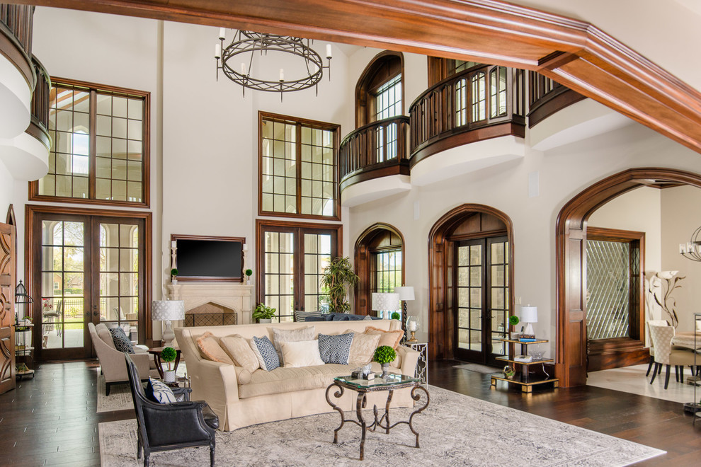 This is an example of a large mediterranean open plan living room in Houston with white walls, dark hardwood flooring, a standard fireplace and brown floors.
