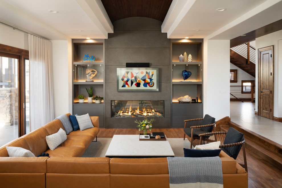 Offenes Modernes Wohnzimmer mit braunem Holzboden, Gaskamin, Kaminumrandung aus Beton, TV-Wand und Holzdecke in Denver