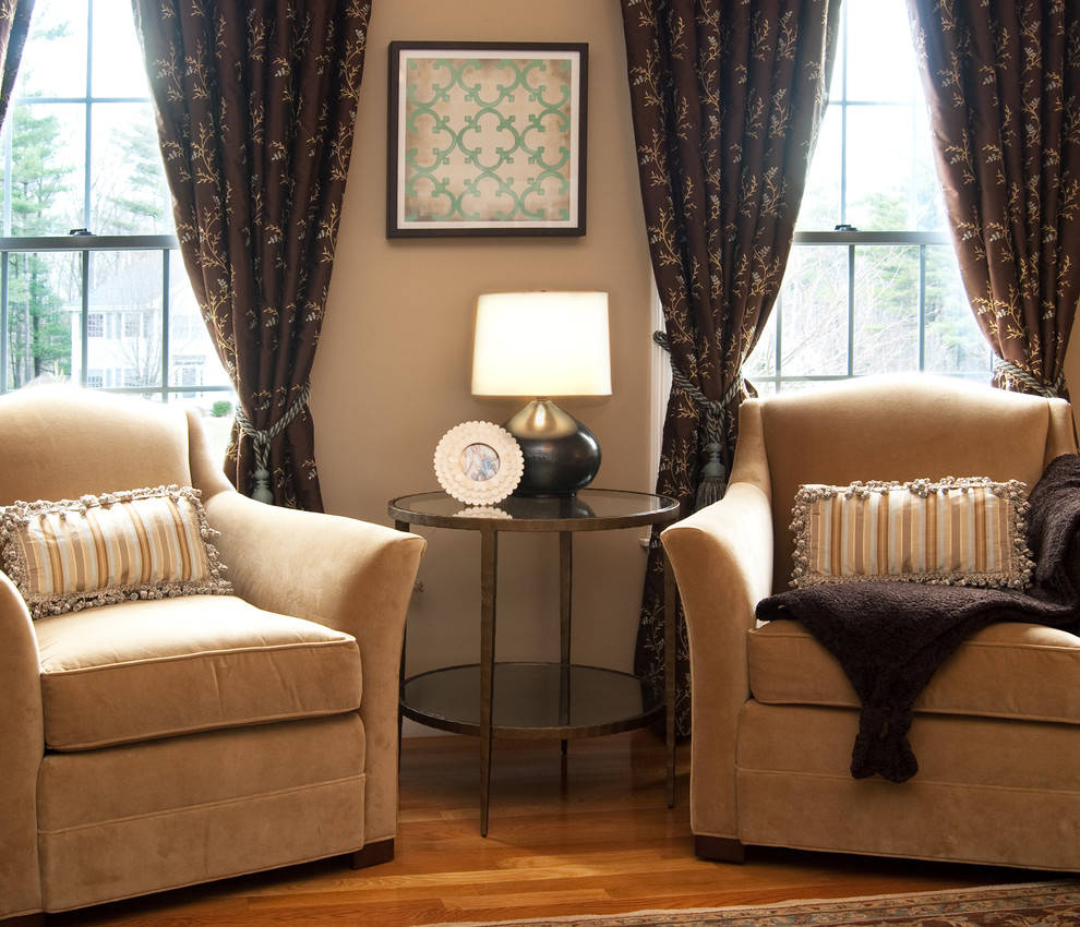 На фото: гостиная комната в классическом стиле с бежевыми стенами и красивыми шторами с