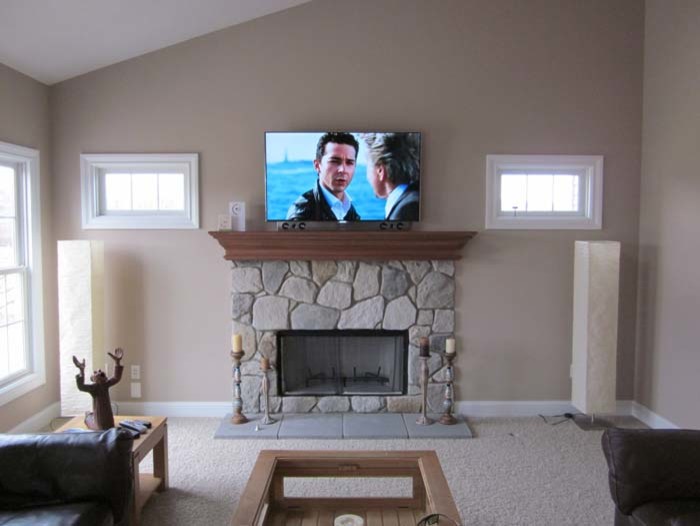 Пример оригинального дизайна: изолированная гостиная комната среднего размера в стиле ретро с бежевыми стенами, ковровым покрытием, стандартным камином, фасадом камина из камня и телевизором на стене