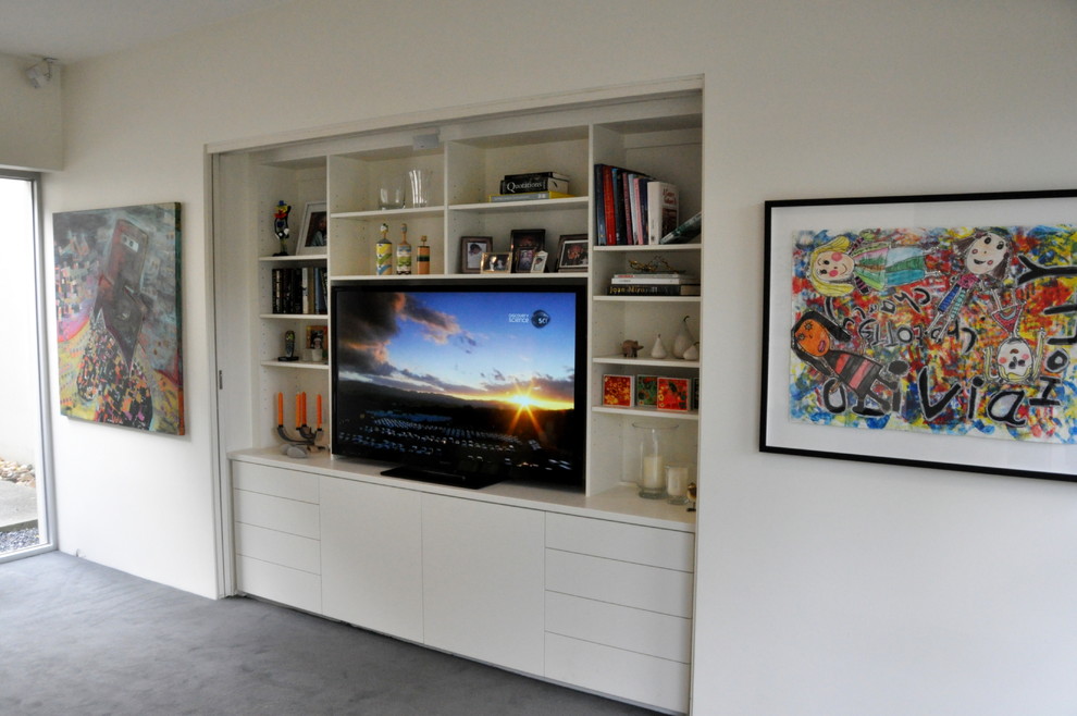 На фото: открытая гостиная комната среднего размера в современном стиле с белыми стенами, ковровым покрытием и мультимедийным центром