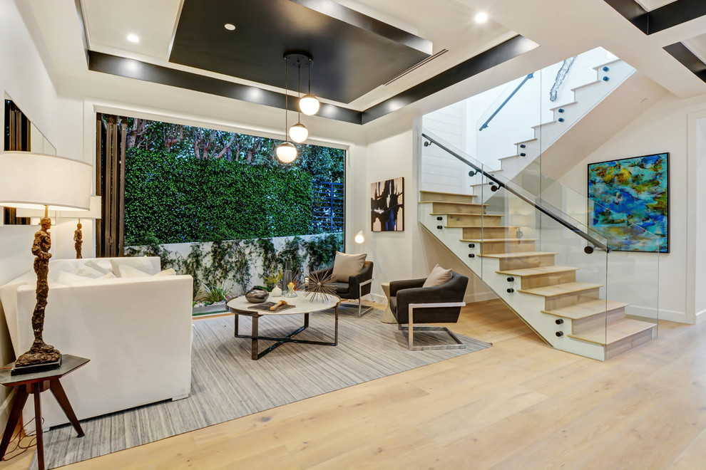 Offenes Modernes Wohnzimmer mit weißer Wandfarbe, hellem Holzboden und beigem Boden in Los Angeles