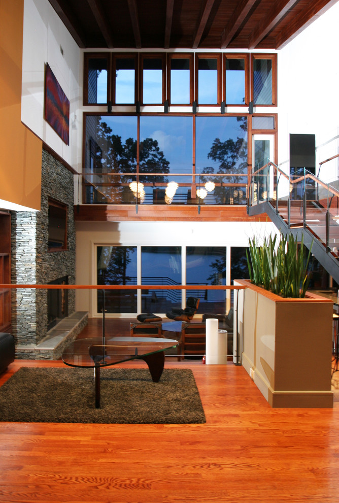 Esempio di un soggiorno moderno di medie dimensioni e aperto con pareti gialle, parquet scuro, camino classico, cornice del camino in mattoni e TV nascosta