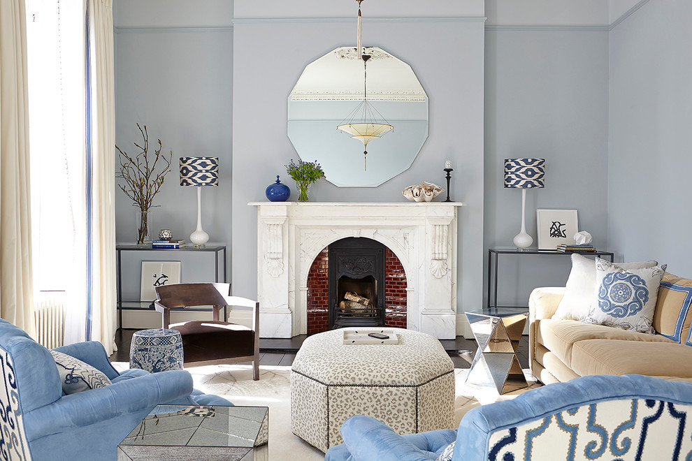 Exemple d'un salon chic avec un mur bleu, une cheminée standard, un manteau de cheminée en brique et aucun téléviseur.