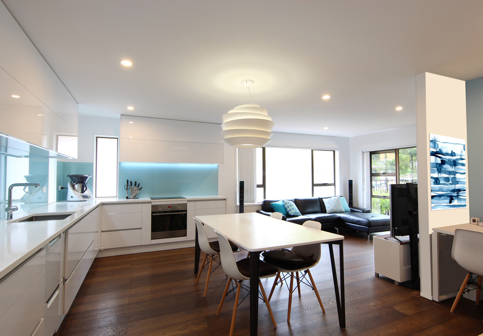 Immagine di un piccolo soggiorno moderno aperto con pavimento in legno massello medio, pavimento marrone, pareti bianche e TV autoportante