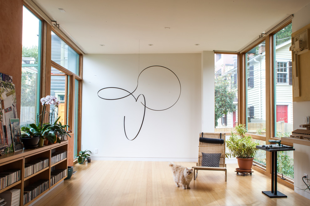 Example of a trendy medium tone wood floor living room design in Other with white walls