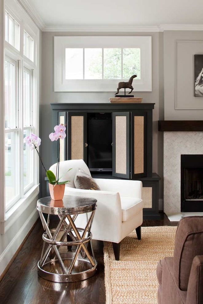 Cette image montre un salon design de taille moyenne et ouvert avec un mur gris, parquet foncé, une cheminée standard et un téléviseur dissimulé.