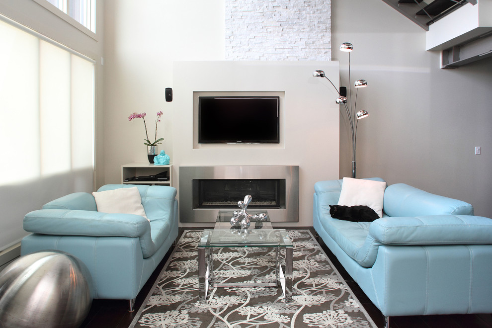 Exempel på ett stort modernt allrum med öppen planlösning, med en bred öppen spis, en spiselkrans i metall, en väggmonterad TV, grå väggar och mörkt trägolv