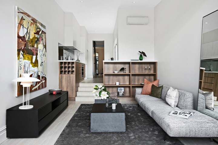 Cette photo montre un salon mansardé ou avec mezzanine tendance avec un mur blanc, parquet clair et un sol gris.