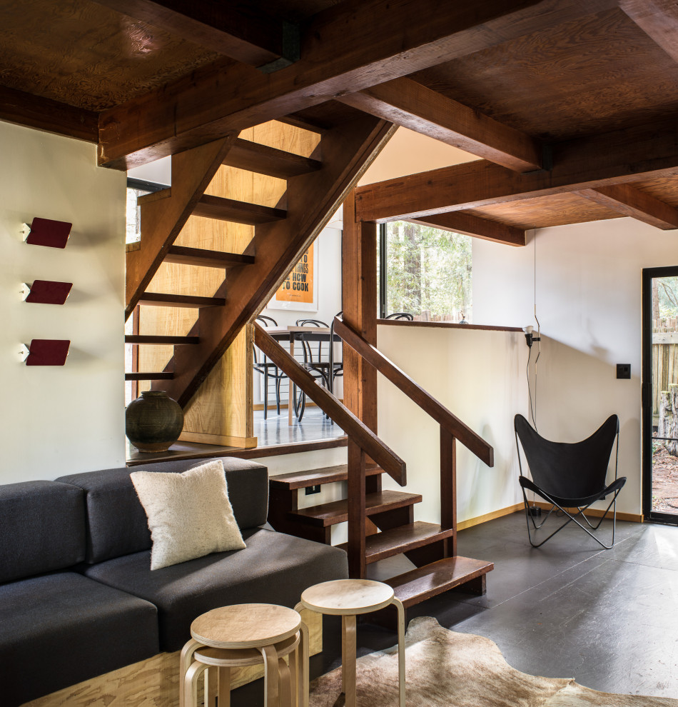 Kleines, Offenes Rustikales Wohnzimmer mit weißer Wandfarbe, gebeiztem Holzboden, Kamin und schwarzem Boden in San Francisco