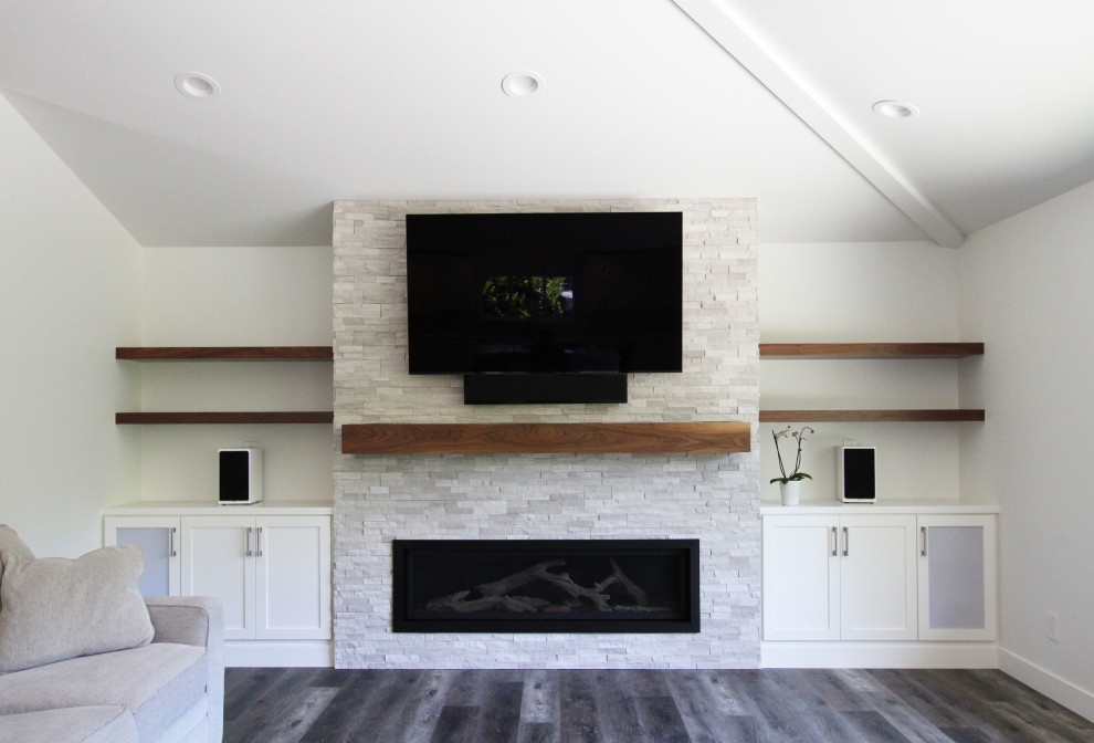 他の地域にある広いトランジショナルスタイルのおしゃれなLDK (白い壁、クッションフロア、横長型暖炉、積石の暖炉まわり、埋込式メディアウォール、茶色い床) の写真