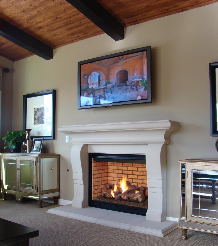 サンディエゴにあるお手頃価格の中くらいなトラディショナルスタイルのおしゃれなLDK (ベージュの壁、無垢フローリング、標準型暖炉、石材の暖炉まわり、壁掛け型テレビ) の写真