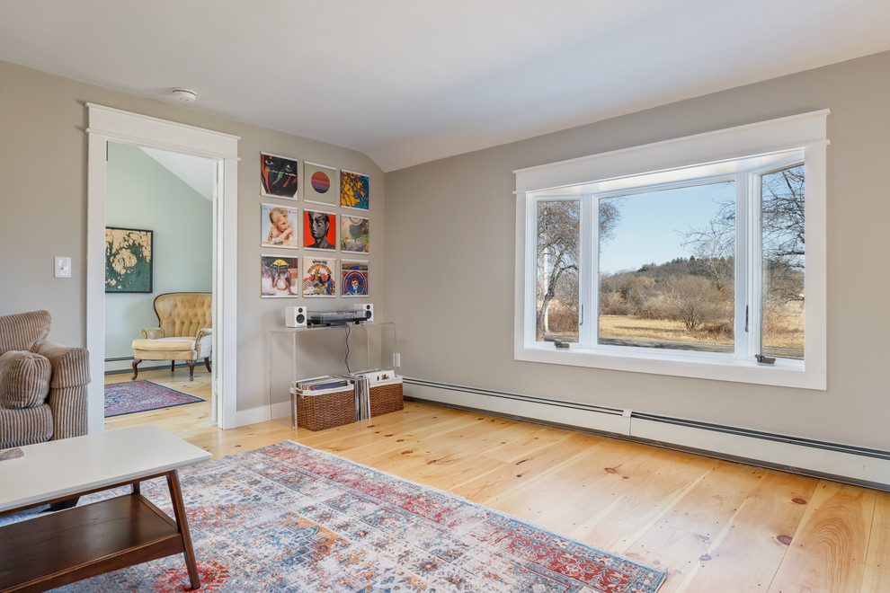 Cette photo montre un salon nature de taille moyenne et fermé avec un mur gris, parquet clair, une cheminée d'angle, un manteau de cheminée en brique, un téléviseur indépendant et un sol beige.
