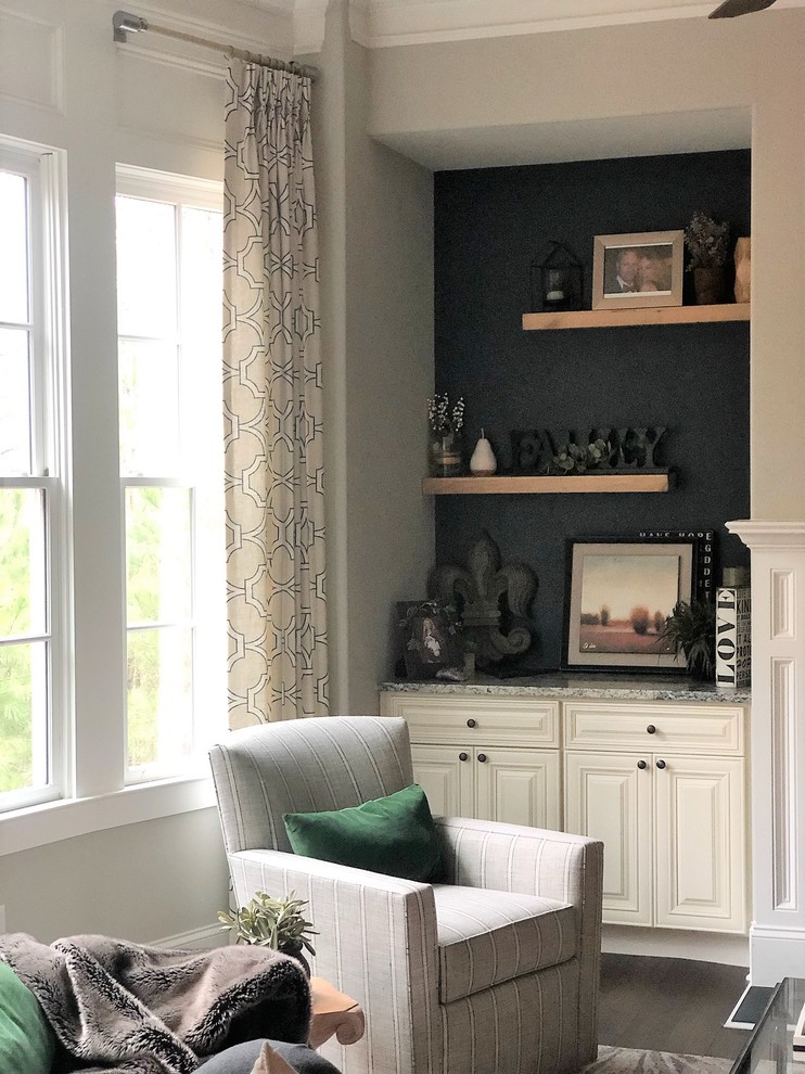 На фото: открытая гостиная комната среднего размера в стиле неоклассика (современная классика) с серыми стенами, темным паркетным полом, стандартным камином, фасадом камина из камня, телевизором на стене и коричневым полом с