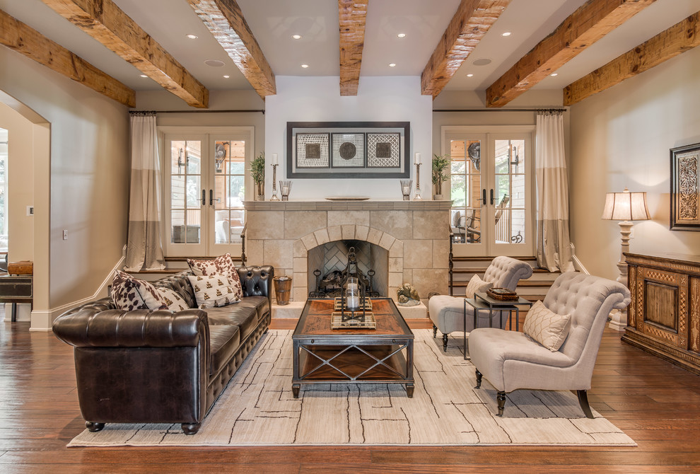 Repräsentatives, Fernseherloses Mediterranes Wohnzimmer mit beiger Wandfarbe, braunem Holzboden, Kamin und gefliester Kaminumrandung in Nashville