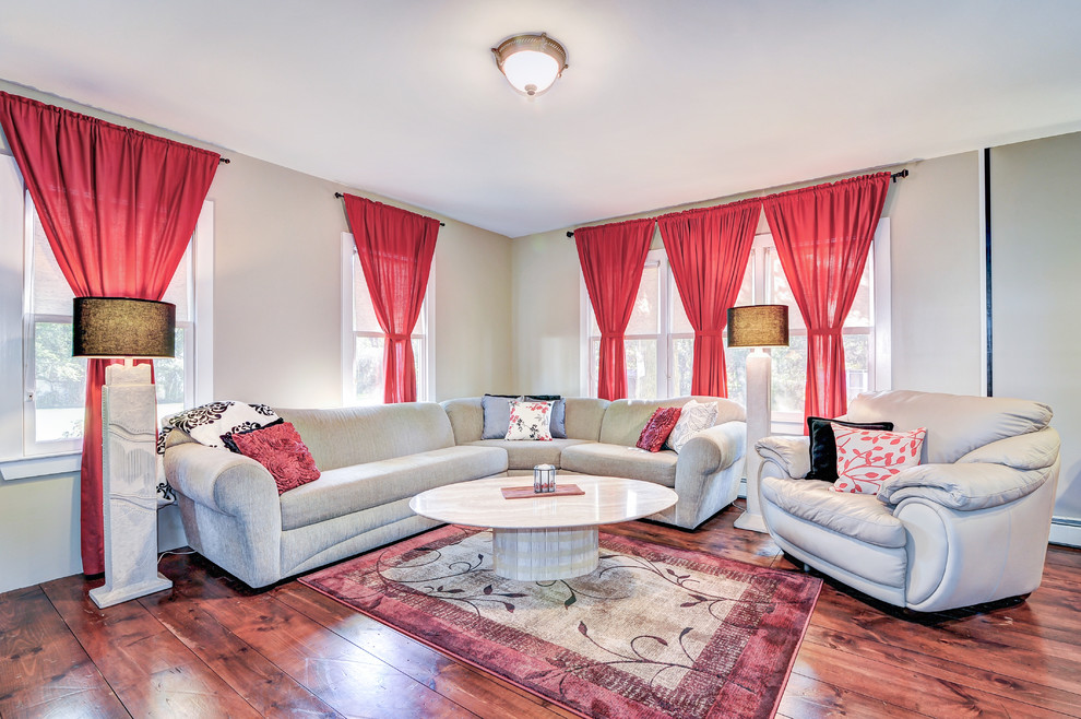 Esempio di un grande soggiorno classico aperto con pareti beige, pavimento in legno massello medio e TV autoportante