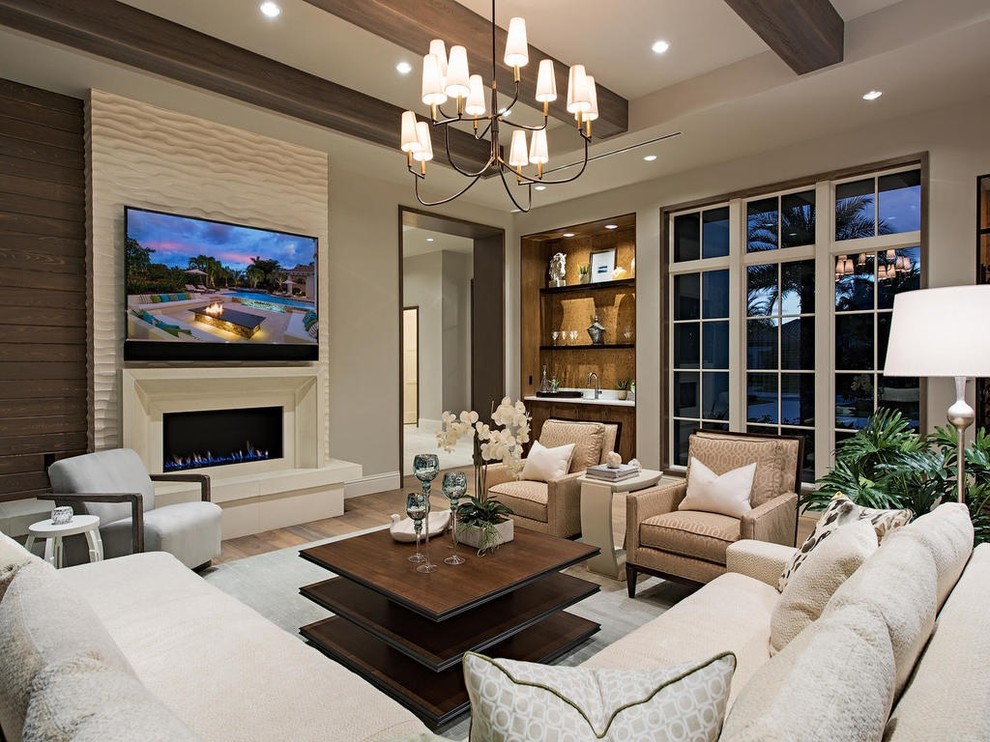Large classic open plan living room in Miami with beige walls, medium hardwood flooring, a standard fireplace, a tiled fireplace surround and a wall mounted tv.