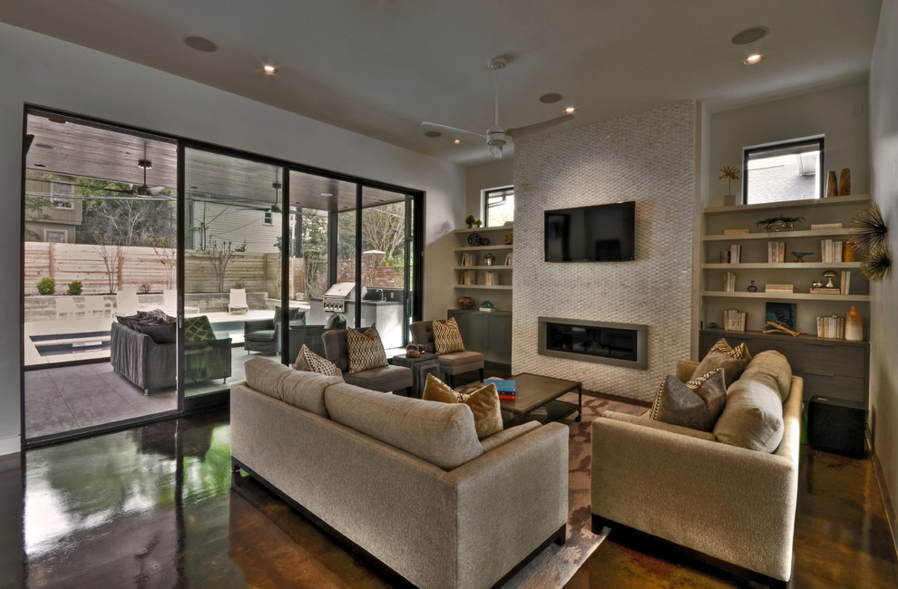 Идея дизайна: гостиная комната в современном стиле с бетонным полом, фасадом камина из плитки и ковром на полу