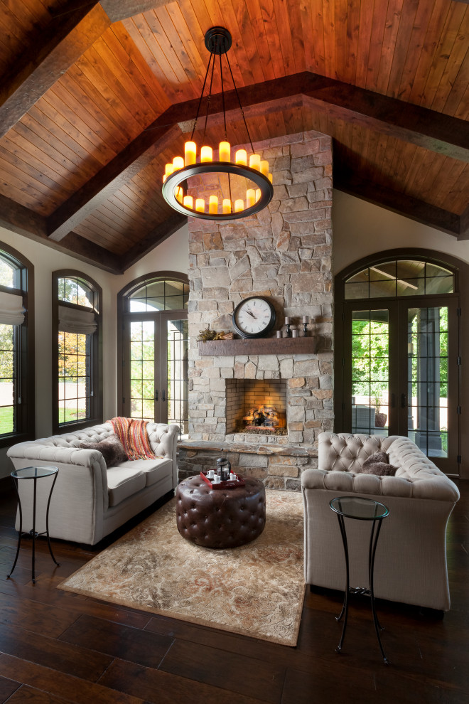 Large rustic formal open plan living room in Detroit with white walls, medium hardwood flooring, a standard fireplace, a stone fireplace surround and brown floors.